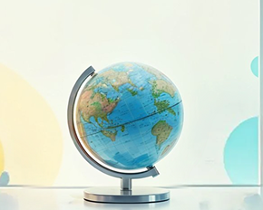 Um globo terrestre apoiado em uma base metálica está centralizado sobre uma superfície clara. O fundo é um gradiente suave de amarelo claro para branco. No canto superior esquerdo, sobreposto à imagem, há uma etiqueta laranja arredondada com o texto "Em breve" em branco.